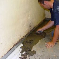 A basement waterproofer installing a perimeter drain system in White Rock