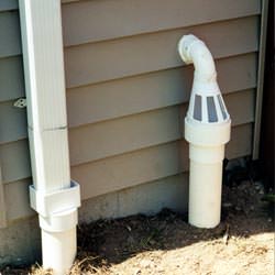 A grated sump pump discharge line fitting in Agassiz