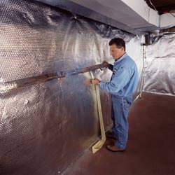 Installation of a radiant heat and vapor barrier on a basement wall in Ladner